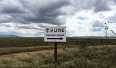 a sign on a dry grass field